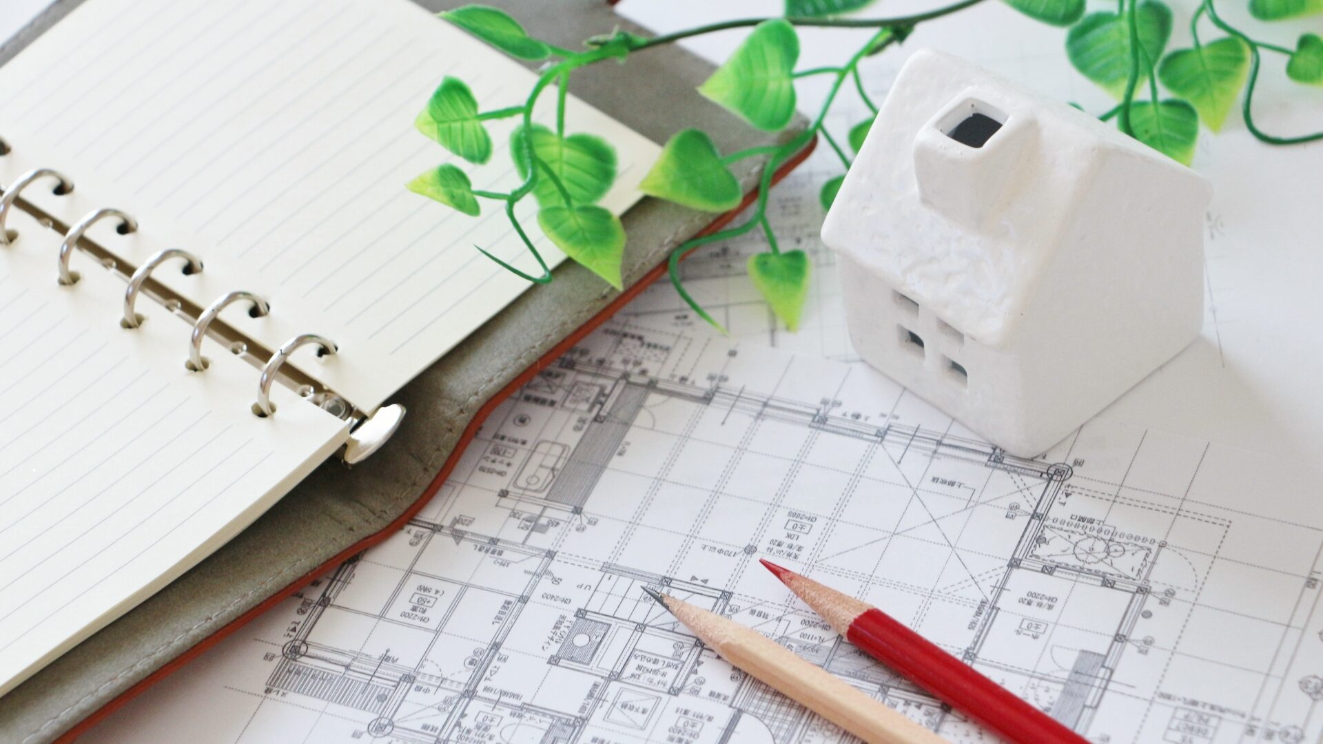 家の模型とノートと設計図