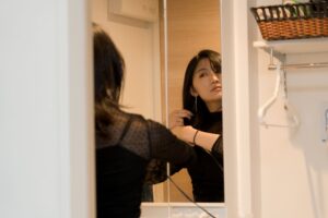 鏡の前で身支度をする女性
